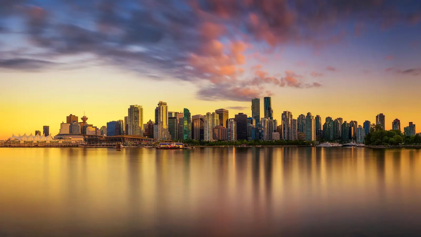 Downtown Vancouver skyline and Canada Place across Coal Harbour at sunset